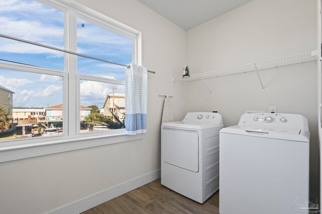 clothes washing area with separate washer and dryer and dark hardwood / wood-style floors