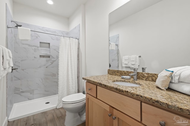 bathroom featuring hardwood / wood-style floors, vanity, toilet, and walk in shower