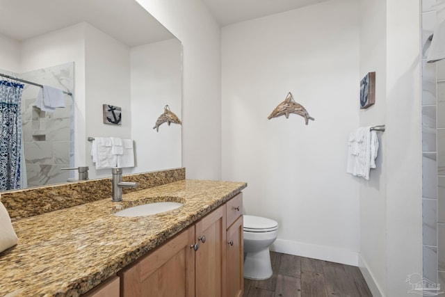 bathroom with hardwood / wood-style floors, vanity, toilet, and walk in shower