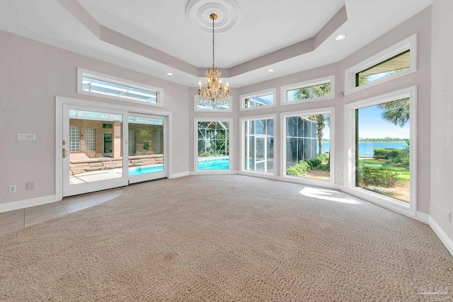 interior space with recessed lighting, carpet flooring, a raised ceiling, and baseboards