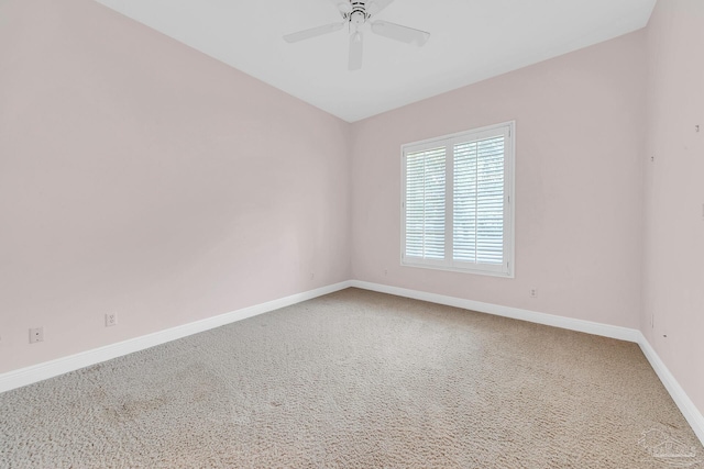 carpeted empty room featuring baseboards and a ceiling fan