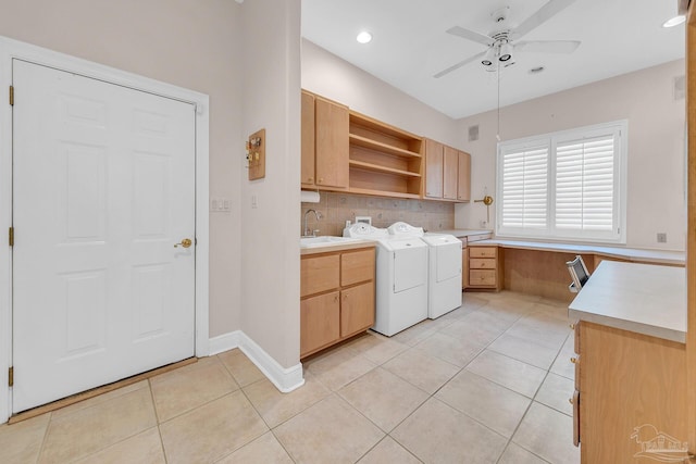 washroom with cabinet space, light tile patterned floors, ceiling fan, washing machine and clothes dryer, and a sink