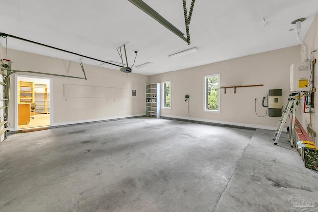 garage with baseboards, tankless water heater, and a garage door opener