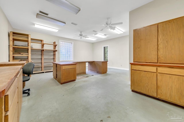 unfurnished office with concrete flooring, visible vents, baseboards, and a ceiling fan