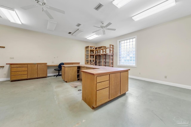 office space with baseboards, concrete floors, visible vents, and ceiling fan