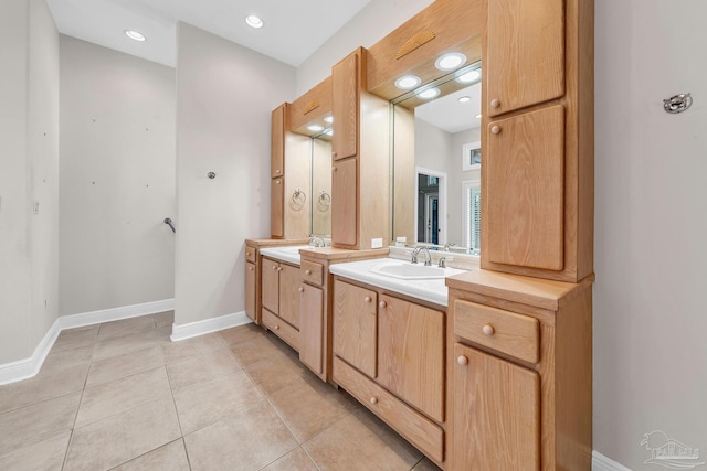 bathroom with baseboards, a sink, tile patterned flooring, two vanities, and recessed lighting