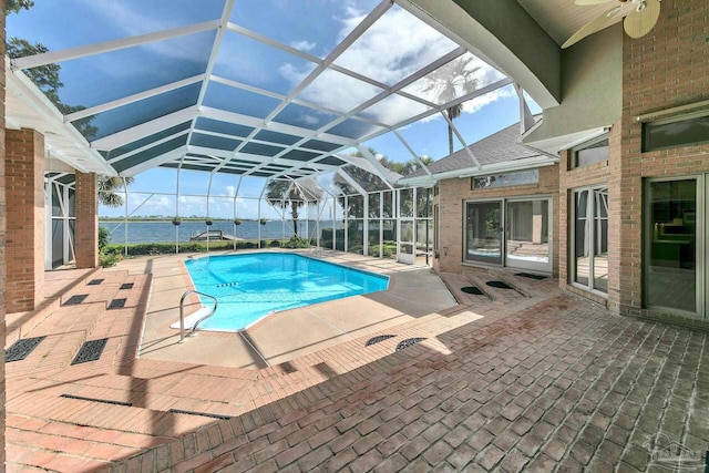 pool featuring glass enclosure, a ceiling fan, and a patio