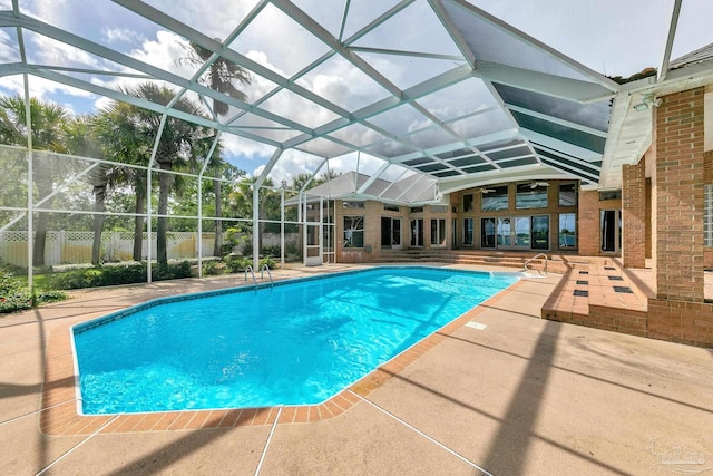 view of swimming pool featuring a lanai, fence, a fenced in pool, and a patio