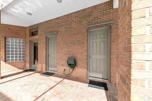 property entrance featuring brick siding