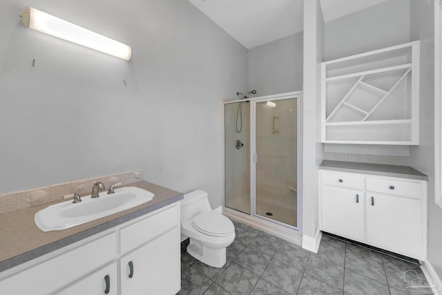 bathroom with a stall shower, vanity, toilet, and tile patterned floors