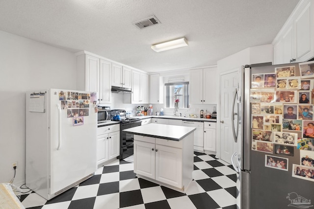 kitchen with stainless steel appliances, white cabinetry, a kitchen island, and a textured ceiling