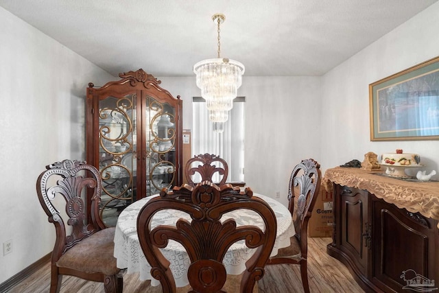 dining room with a notable chandelier and light wood-type flooring