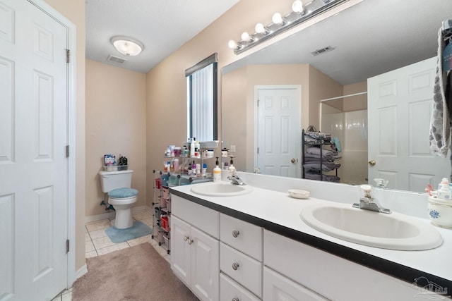 bathroom with a shower, vanity, toilet, tile patterned floors, and a textured ceiling