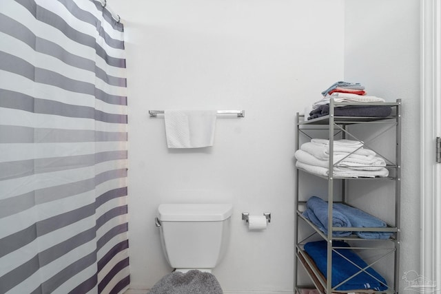 bathroom with a shower with curtain and toilet