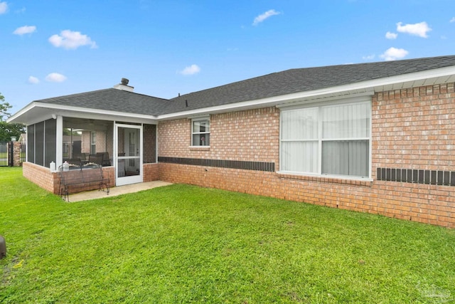 rear view of property featuring a lawn and a sunroom