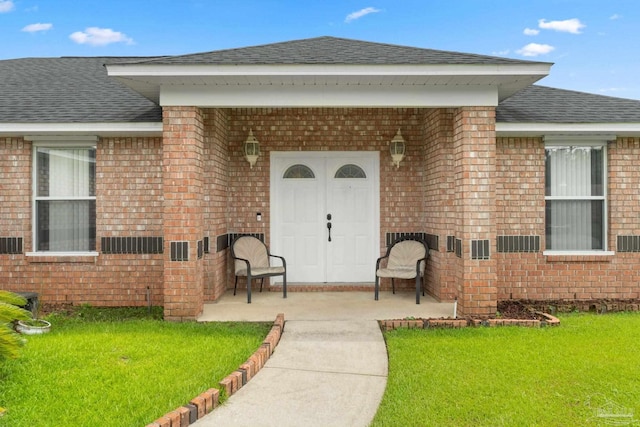 entrance to property with a lawn and a patio