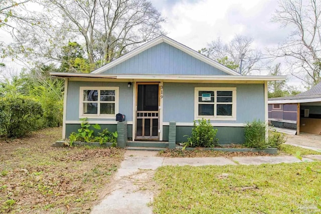 bungalow with a front yard and a porch