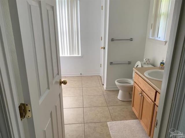 bathroom with baseboards, vanity, toilet, and tile patterned floors