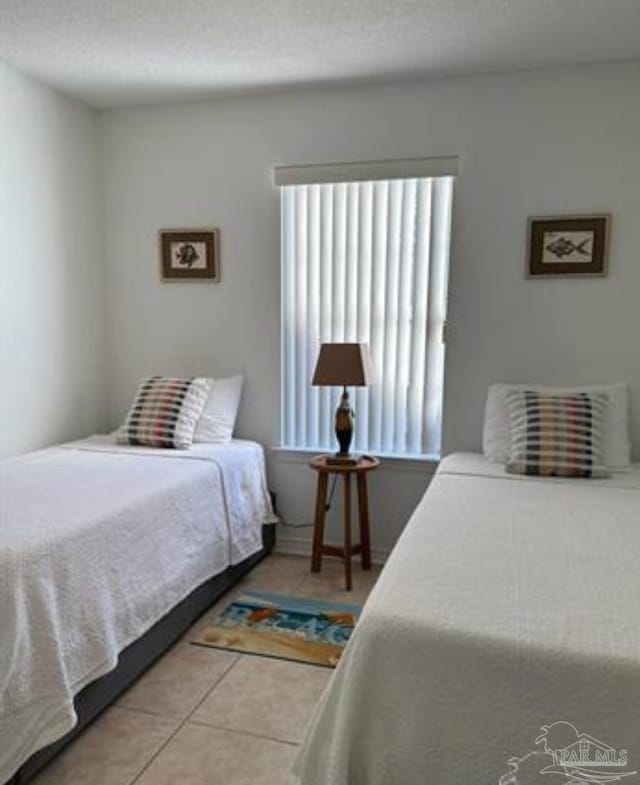 tiled bedroom with a textured ceiling