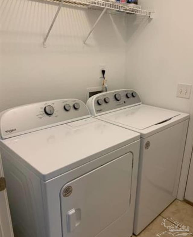 laundry area with laundry area, light tile patterned flooring, and independent washer and dryer