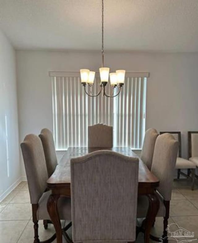 dining area featuring light tile patterned floors, plenty of natural light, baseboards, and an inviting chandelier