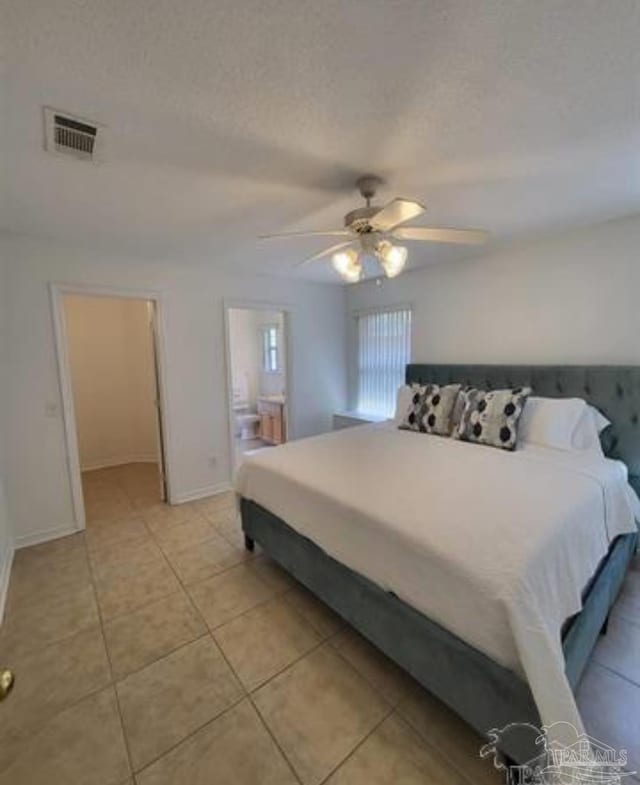 bedroom with light tile patterned floors, visible vents, ceiling fan, a textured ceiling, and baseboards