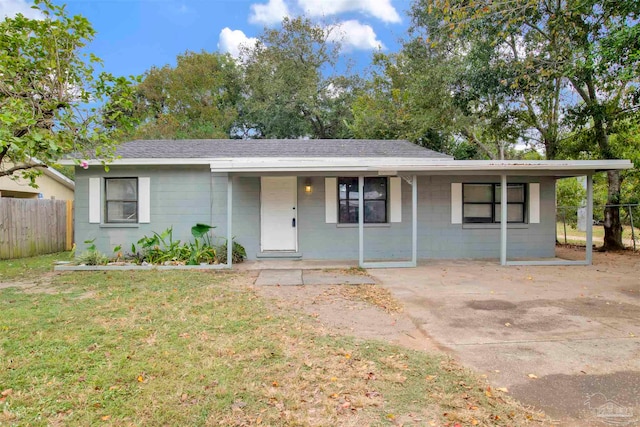 ranch-style home featuring covered porch and a front lawn