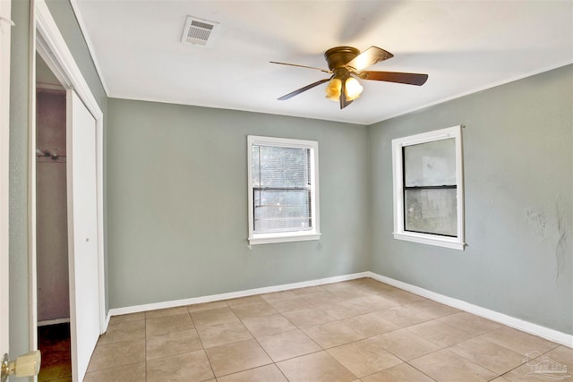 unfurnished bedroom with a closet, light tile patterned floors, and ceiling fan