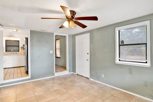 tiled empty room featuring sink and ceiling fan