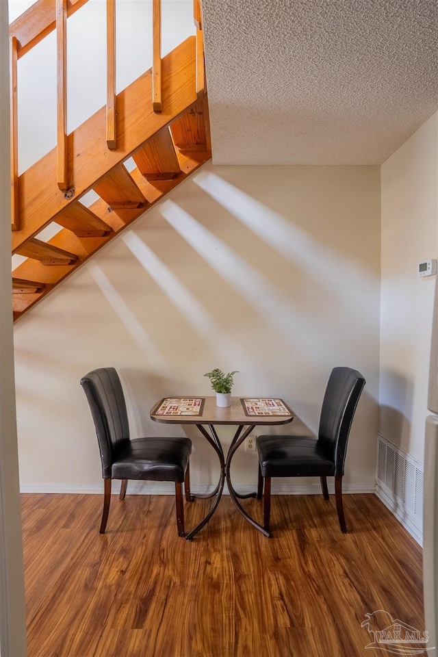 living area featuring dark wood-style flooring, visible vents, and a textured ceiling