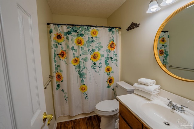 full bath with a textured ceiling, curtained shower, toilet, wood finished floors, and vanity