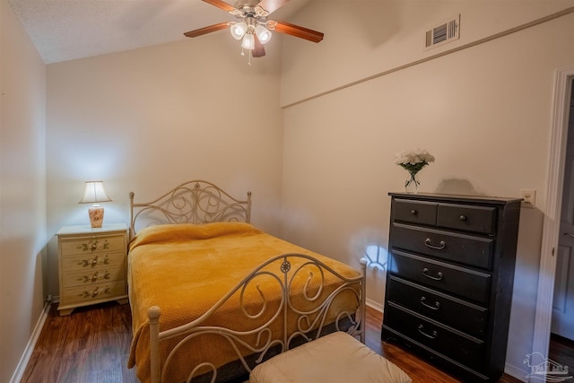 bedroom featuring baseboards, visible vents, dark wood finished floors, a ceiling fan, and lofted ceiling