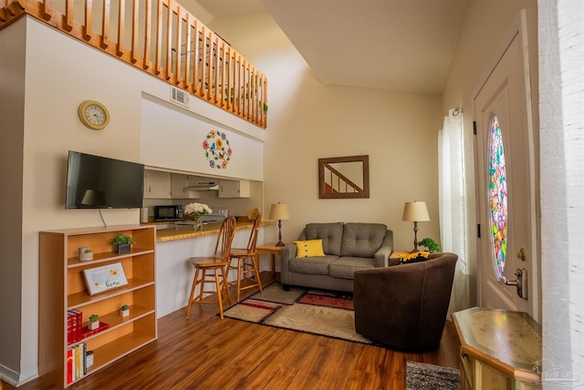 living area with visible vents and dark wood finished floors