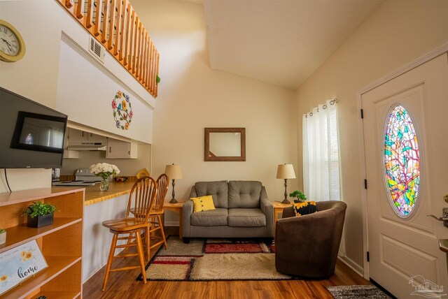 living room featuring high vaulted ceiling and wood finished floors