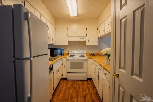 kitchen with light countertops, white appliances, white cabinetry, and under cabinet range hood