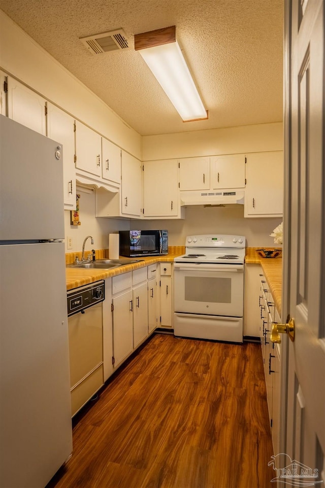 kitchen featuring light countertops, white appliances, under cabinet range hood, and white cabinets