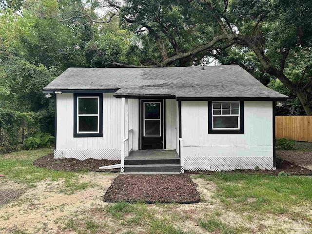 view of front of property featuring a shingled roof and fence