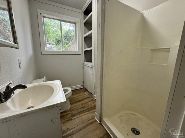 full bathroom featuring vanity, a shower stall, toilet, and wood finished floors