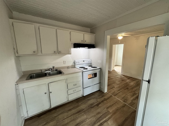 kitchen with white appliances, dark wood-type flooring, range hood, light countertops, and a sink