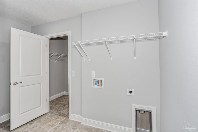 washroom featuring a textured ceiling, hookup for a washing machine, and electric dryer hookup