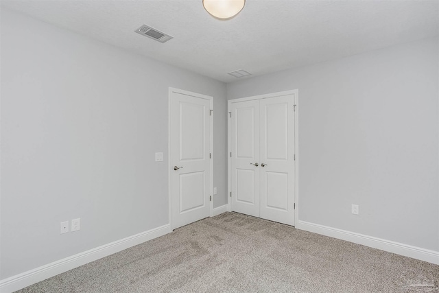 empty room featuring a textured ceiling and carpet flooring