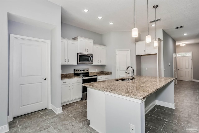 kitchen with sink, appliances with stainless steel finishes, white cabinets, and an island with sink