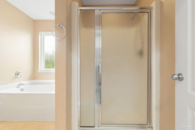 bathroom with shower with separate bathtub and a textured ceiling