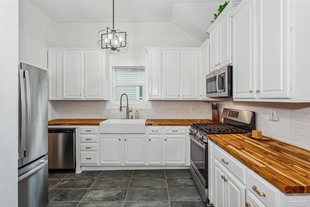 kitchen featuring sink, butcher block countertops, decorative backsplash, and stainless steel appliances