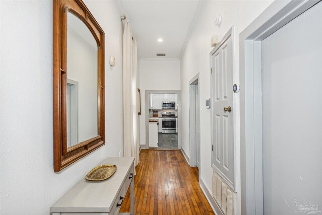 hall with ornamental molding and hardwood / wood-style floors