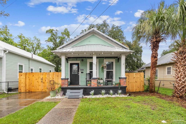 bungalow-style home with a porch and a front lawn