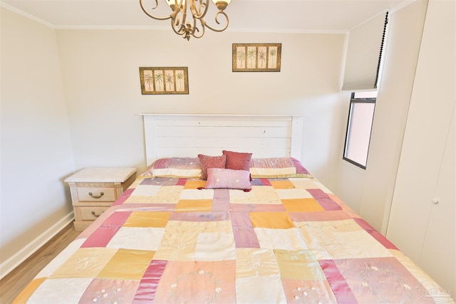 bedroom featuring hardwood / wood-style flooring, crown molding, and a chandelier