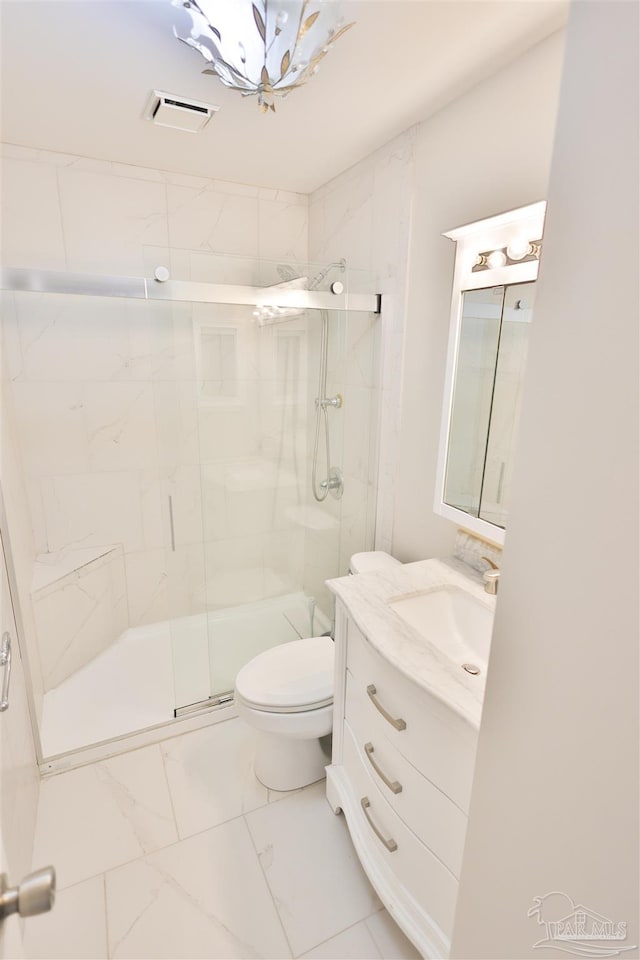 bathroom featuring vanity, a shower with door, and toilet