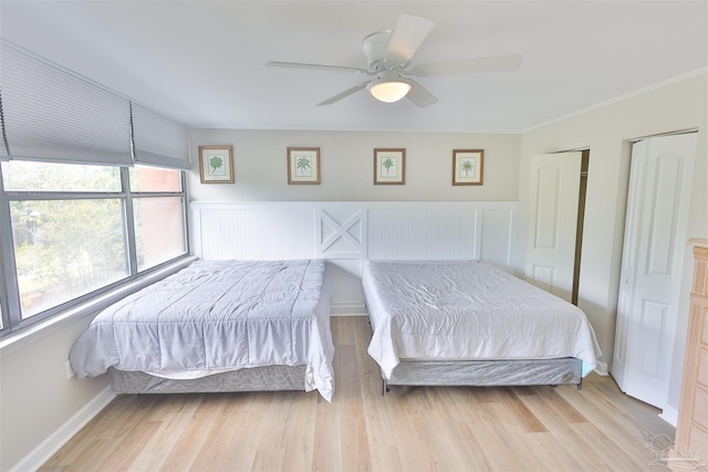 bedroom with light wood-type flooring, crown molding, and ceiling fan