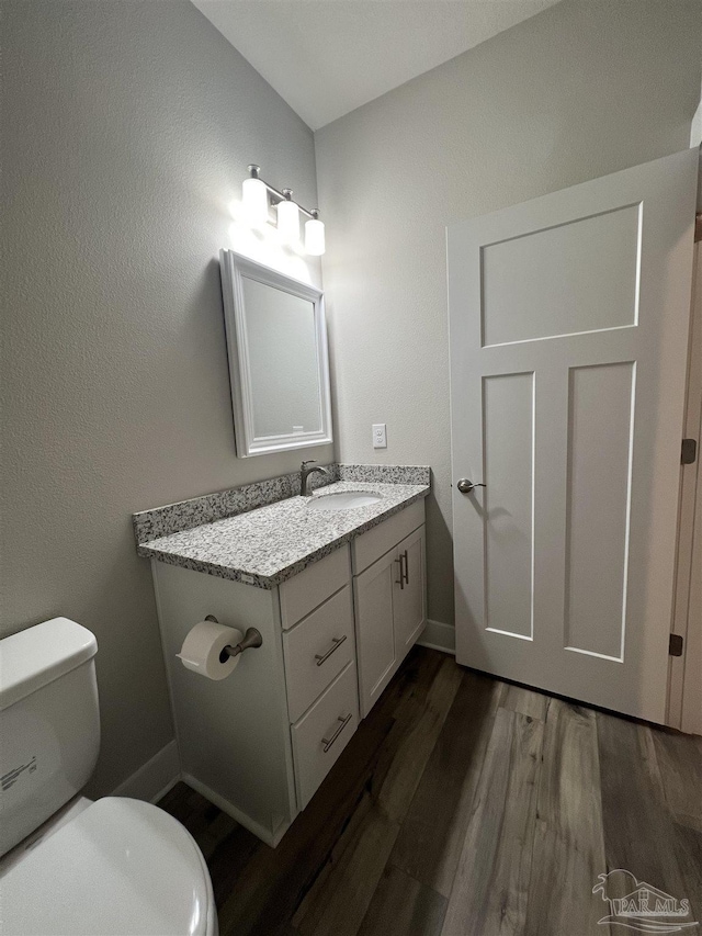 bathroom featuring hardwood / wood-style floors, vanity, and toilet